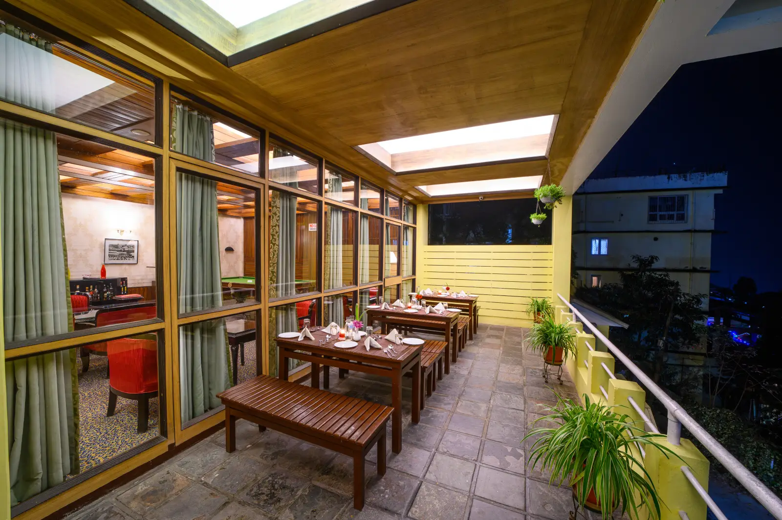 Lobby-level balcony dining area with mountain views at Sinclairs Darjeeling