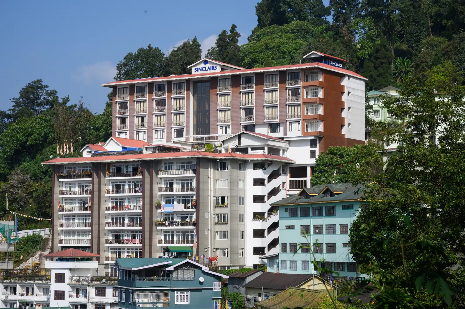 Sinclairs Gangtok building facade set against the forested hillside