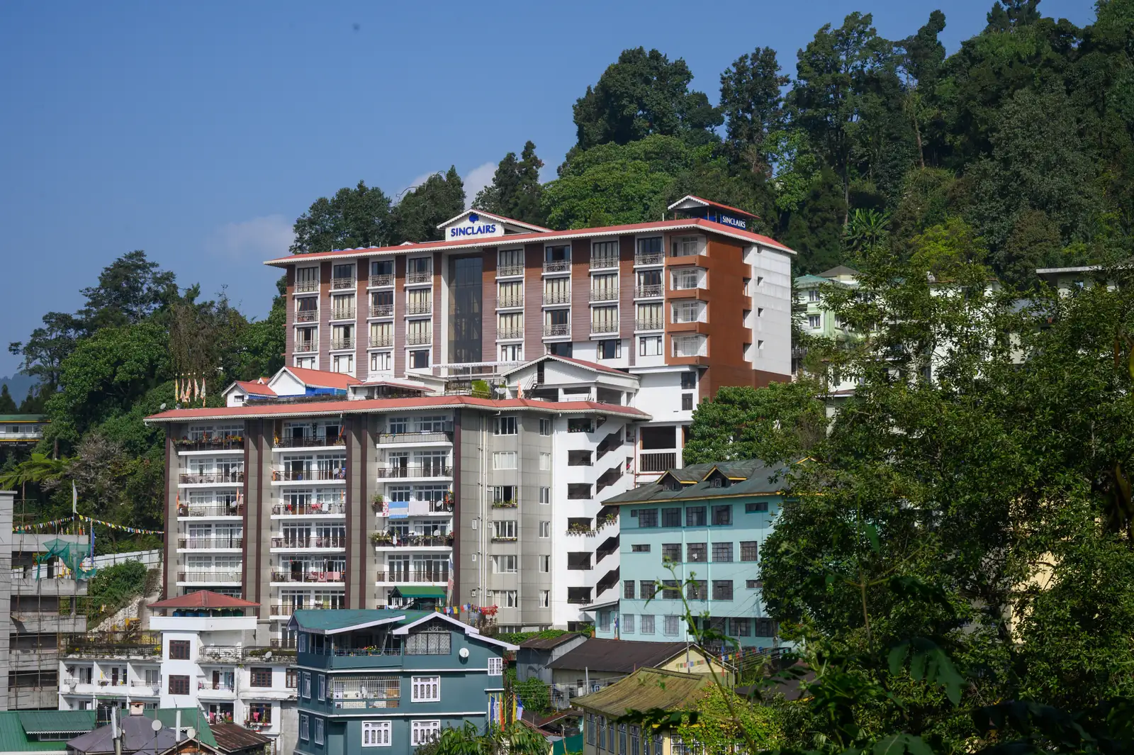 Close-up of the Sinclairs Gangtok signage and tiered rooftop